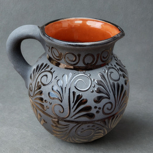 Ceramic pitcher with decorative patterns on a gray background