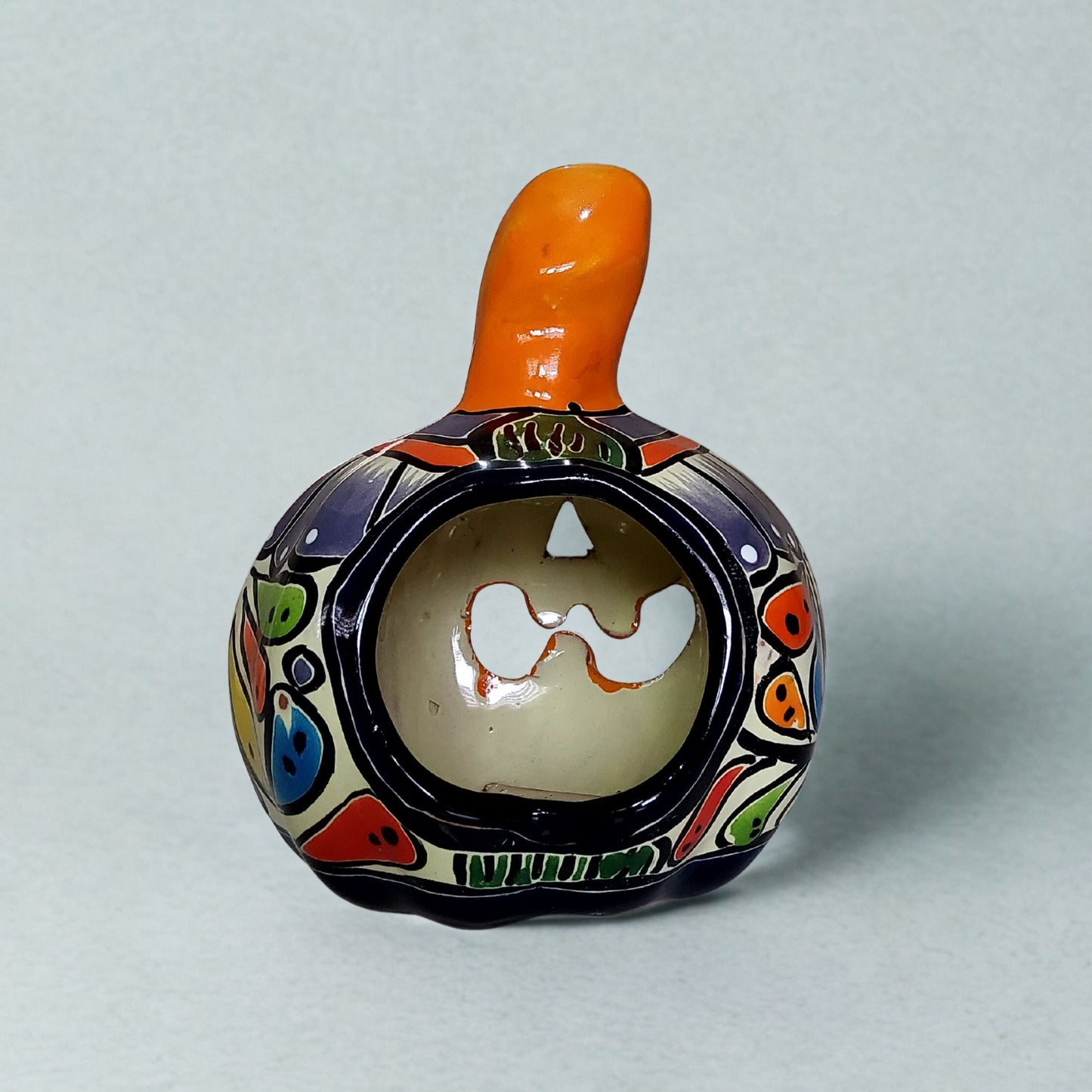 Decorative ceramic bottle with colorful patterns on a light gray background