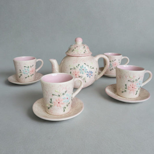 Ceramic tea set with floral designs on a gray background