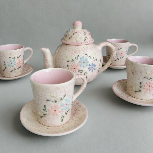 Ceramic tea set with floral designs on a gray background