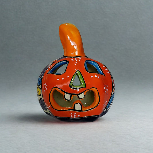 Ceramic pumpkin with a face on a gray background